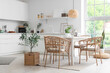 © Pixel-Shot - Interior of light dining room with table and wicker chairs