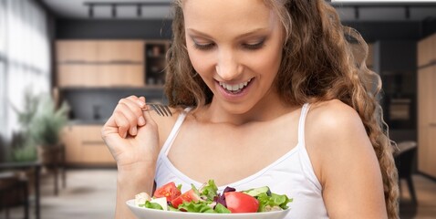 Athletic young woman eating a vegetable salad