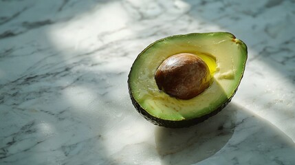 Sticker -   Avocado sliced in two on a marble countertop with adjacent halves