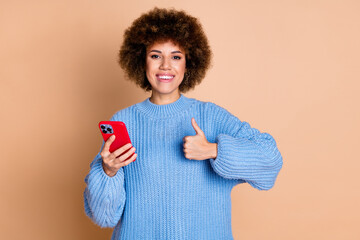 Canvas Print - Photo of satisfied girl with perming coiffure dressed blue sweater hold smartphone showing thumb up isolated on pastel color background