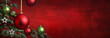 © Smileus - Red Christmas background banner with hanging baubles and starsas decoration on the branches of a fir tree. Beautiful handmade texture, vignetted and empty as copy space.