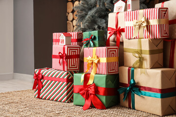 Gift boxes near Christmas tree in room