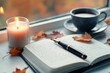© SnapVault - A peaceful autumn scene with an open journal, a lit candle, and a cup of coffee on the windowsill. Autumn leaves scattered around create a cozy and serene writing environment.