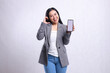 © Ajab - expression of adult beautiful office woman cheerful to camera sign of love affection showing cellphone screen wearing gray suit isolated on white background. for technology, lifestyle, promotion