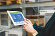 © VisualProduction - The young female owner and the man in the warehouse check the temperature, energy consumption and lights on a tablet.