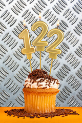 Poster - Chocolate cupcake with candle number 122 - Birthday on industrial metallic background.