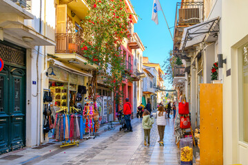 A colorful narrow street of shops, boutiques and cafes in the picturesque old town of Nafplio, Greece, a seaside town in the Southern Peloponnese district.