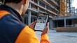 © Faizatun - Construction Worker Using Smartphone to View Building Progress