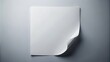 © Kukar Studio - A single white sheet of paper with a curled corner, affixed to a light grey surface.
