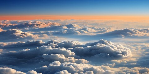 Canvas Print - A panoramic view of fluffy white clouds illuminated by a warm sunrise, stretching across a vast expanse of sky.