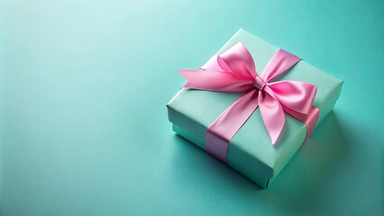 Wall Mural - A Delicate Light Blue Gift Box With A Pink Bow On A Smooth Teal Background