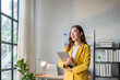 © Wasana - Young asian businesswoman holding laptop and thinking in office