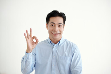 Portrait of Asian young man showing okay sign on white background