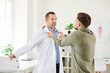 © Studio Romantic - Portrait of aggressive male patient fighting and arguing with doctor standing in medical clinic. Angry man dissatisfied with treatment and and yelling at physician. Medicine concept.
