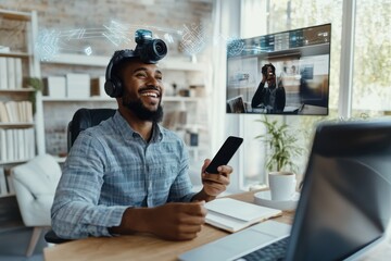 Smiling man with headphones and camera on his head working on a laptop and looking at his phone