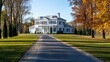 © Elmin - A picture shows a brand new, white house with a long, paved driveway.