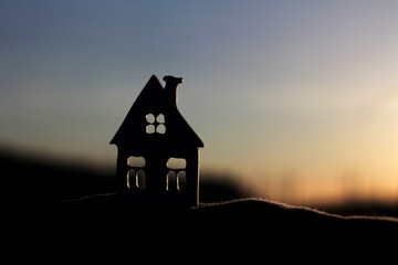 silhouette of a model of an old village house in the rays of the sun. shadows of old villages