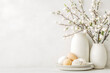 © AlexCobalt - Elegant easter decor with cotton branches and eggs on minimalistic background