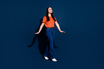 Wall Mural - Photo of excited pretty cute woman wear orange stylish clothes look empty space isolated on dark blue color background