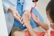© Stone Story - Doctor examines child's hand during medical check-up, focusing on health assessment and patient care in a friendly environment.