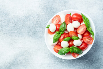 Basil leaves , cherry tomatoes and mozzarella cheese . In bowl food photography