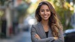 © CinimaticWorks - professional confident businesswoman smiling and standing outdoors on the street with arms crossed showcasing her positive attitude and success as a female entrepreneur
