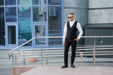 Dapper Urban Elegance: A Stylishly Attired Man Poses Confidently in a Modern Cityscape