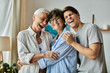 © Bliss - Lesbian parents and their adult son enjoy a heartwarming moment filled with laughter at home.