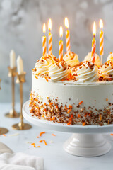 Orange and white birthday cake with dripping frosting and lit candles, decorated with sprinkles, perfect for birthday celebrations and festive events.