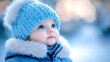 © Diffin - A baby in a blue hat gazes up in awe at the winter surroundings, bundled warmly against the cold snow.
