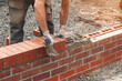 © Iryna - Crafting sturdy brick wall on construction site with skilled hands in the warm afternoon light