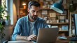 © sungedi - A man with a beard working on a laptop in an office setting