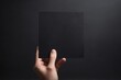 © Introvertia - Minimalist black card held against dark background perfect for mockups