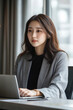 © wolfhound911 - A young adult Japanese female lawyer, engaged in a legal consultation on a video call from a minimalist office space, demonstrating focus and professionalism.