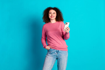 Wall Mural - Portrait of nice young girl smart phone look empty space wear pink sweater isolated on turquoise color background