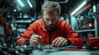 © svastix - A dedicated technician in a red jacket carefully works on assembling components of a complex device, surrounded by various electronic tools in a workshop.