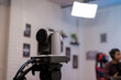 © InveStock - A PTZ camera with a 3g-SDI cable plugged in is recording the live streaming podcast process on the creator's content channel with a background of neon box lights and a minimalist interior above