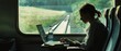 © Ai Studio - A woman works on her laptop while traveling on a scenic train, with a lush landscape visible through the window. A serene moment of productivity and solitude.
