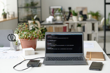 Wall Mural - High angle shot of contemporary workspace in office, laptop, plant in clay pot and office supplies on table top