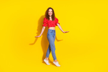 Poster - Full length photo of lovely young lady graceful walking dressed stylish red garment isolated on yellow color background