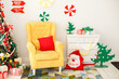 © Olga Mishyna - Stylish funny bright and colorful Christmas interior with a soft yellow armchair and a commode. Comfort home decorated by candies