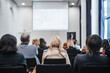© kasto - Speaker giving a talk in conference hall at business event. Rear view of unrecognizable people in audience at the conference hall. Business and entrepreneurship concept