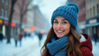 © Georgiy - Beautiful happy young woman in blue knitted hat and scarf against winter city background. Banner.