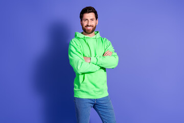 Poster - Photo portrait of attractive young man crossed hands confident dressed stylish green clothes isolated on violet color background