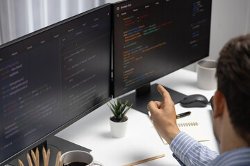 Wall Mural - it developer man pointing information on laptop screen at back side view, thinking program update an