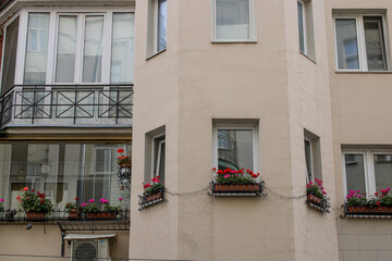 There are three distinct windows located on the side of a white building