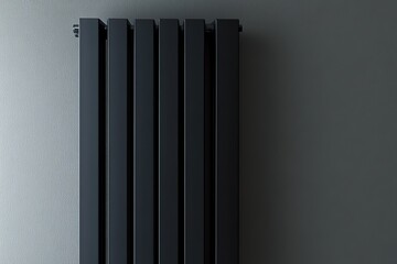 Black vertical heater radiator on grey wall background