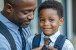 © Pooja - Close up of loving African American father tying tie for son first day of school, Generative AI