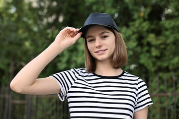 Poster - Portrait of smiling woman in baseball cap outdoors