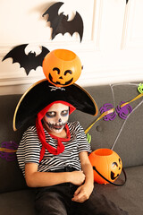 Canvas Print - Funny boy with Halloween decor dressed like pirate on sofa indoors